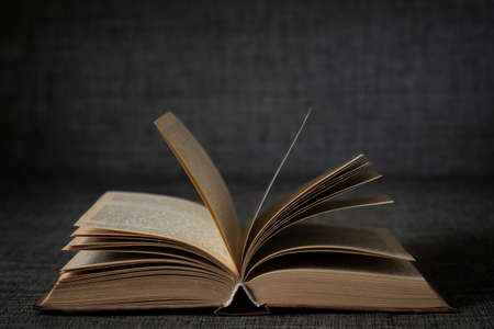 Old open book on a dark background close-upの写真素材
