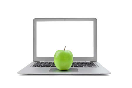 Laptop with blank screen and green apple isolated on white backgroundの写真素材