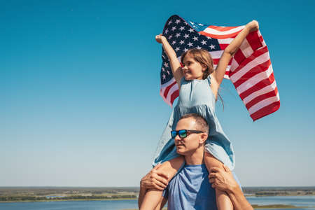 Happy family father and child with USA flag enjoy nature. The concept of freedomの写真素材