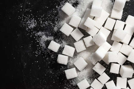 Sugar cubes on a black background. Cubic sugar background with copy space. Top viewの写真素材
