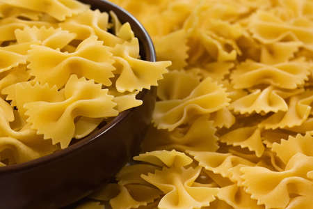 Raw farfalle pasta in a plate close-up. Pasta in the studioの写真素材