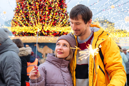 Happy people with Christmas sparklers outdoors on a winter day.の写真素材