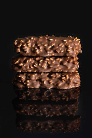 Chocolate with nuts with reflection on black background