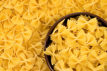 Raw farfalle pasta in a plate close-up. View from aboveの写真素材