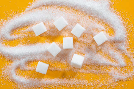 Refined sugar in cubes on a yellow background. View from aboveの写真素材
