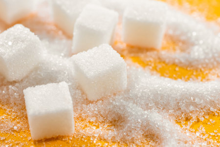 Cubes of refined sugar on a yellow table close-upの写真素材