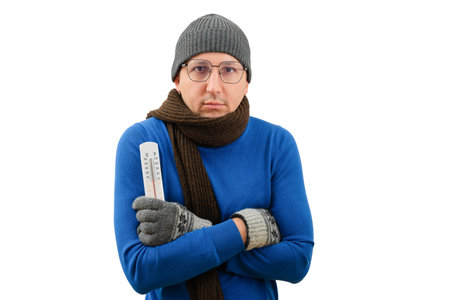 Cold winter season. A man in warm clothes with a thermometer in his hands looks at the camera on a...