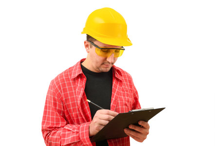 Portrait of a male builder in a helmet signing a contract on a white background. Construction, development, teamworkの写真素材