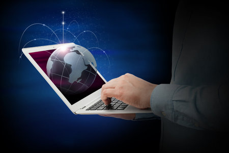 Businessman with a laptop in his hands. Global network and data exchange around the world. Concept of business, digital marketingの写真素材
