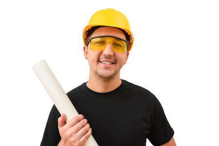 Male engineer in yellow helmet looking at camera on white background. Construction concept. Worker with a projectの写真素材