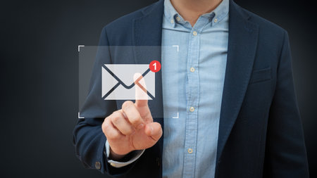 Business man touches email on a virtual screen. Global network and data exchange in human hands. Wireless connection technology.の写真素材