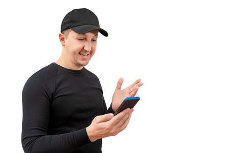 Young man in a baseball cap using a smartphone on a white background.