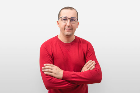 Confident young man in casual sweater looking at camera on white.の写真素材