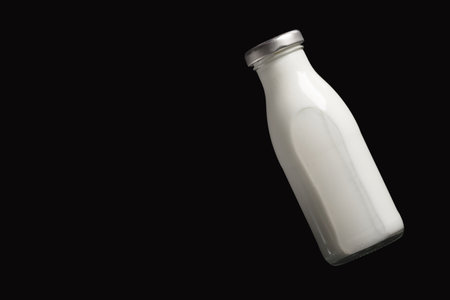 Milk bottle on black background, top view.の写真素材