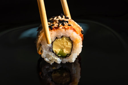 Close-up of sushi roll on black background.の写真素材