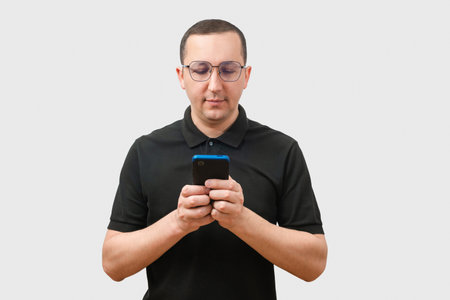 Young man using a phone, isolated on a light gray background