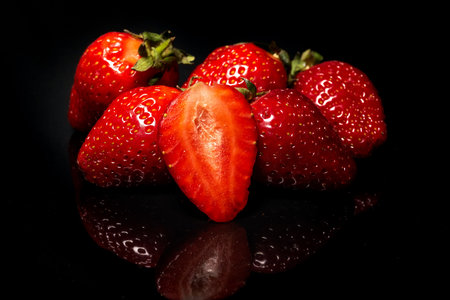 Ripe red strawberries on a black background. Fresh organic berryの写真素材