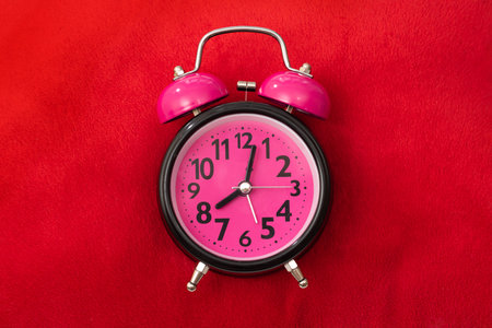Close-up of a red pillow and alarm clock. Top view, Time concept