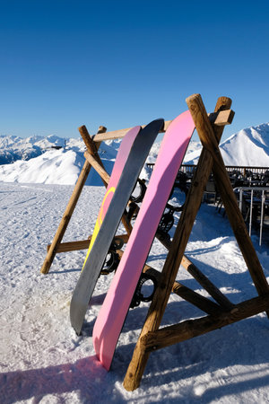 Snowboards stacked on a fence outside on a winter dayの写真素材