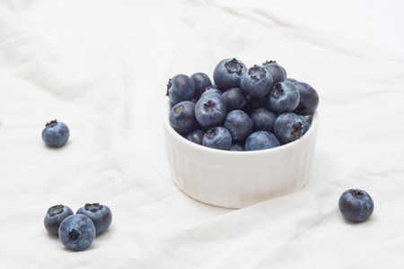 Bowl of fresh blueberries on white background. Organic farm blueberriesの写真素材