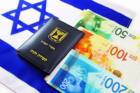 Passport Israel and Israeli shekel (currency ILS)  on Israel flagの写真素材