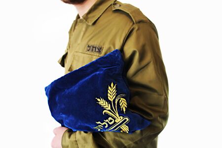 Concept: IDF, Religion in army of Israel. Religious soldier with jewish prayer set on a white background (Hebrew translation of the inscription on the bag - Tallit, on the uniform of a soldier - IDF)の写真素材