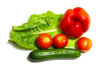 Vegetables on a white isolated background: green cucumber, red tomatoes, red bell pepper or sweet pepper and lettuce. Concept: Fresh vegetables gifts of nature