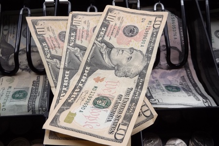 Three ten dollar bills on top of cash drawerの写真素材