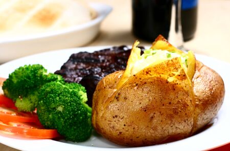 baked potato with cream and steakの写真素材