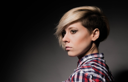 Close-up of a girl with a short haircut. Dark backgroundの写真素材