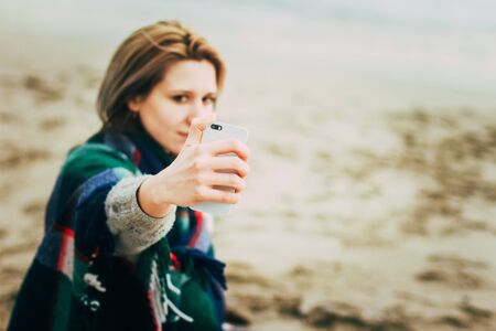 Woman doing selfie phone. Close-up of hand and phone in Focusの写真素材