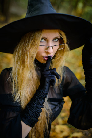 Happy halloween witch girl keeps orange pumpkinの写真素材