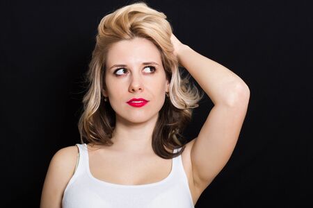 Woman with blonde curls and red lipstick on a dark background closeupの写真素材