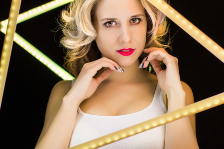 Woman with blond curls laying close-up on a dark backgroundの写真素材
