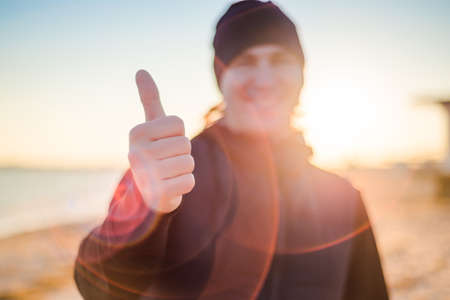 The man is showing a thumbs up on a blurred background. Close-upの写真素材