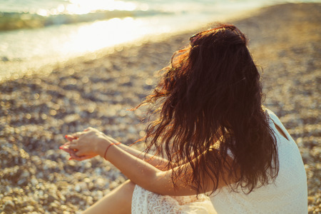 Brunette girl on the background of the sea sunset close up