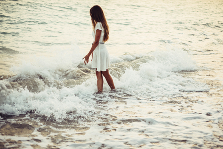 A woman is walking by the sea aloneの写真素材