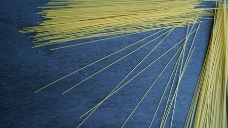 Uncooked pasta on a blue backgroundの写真素材