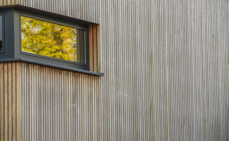 Reflections of flowers in a window in a wooden wall.の写真素材