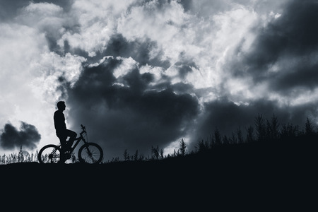 biker standing on top hill