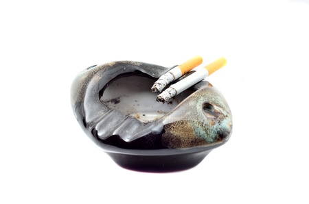 Overhead of burning cigarette in ashtray  on white background with DEATH textの写真素材
