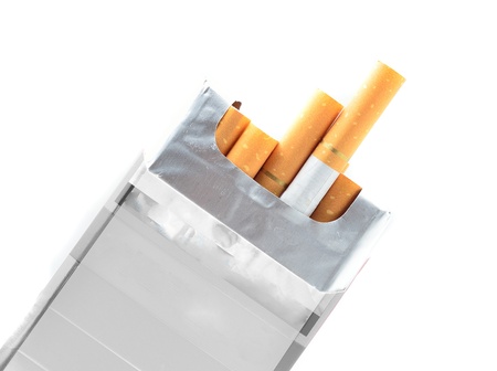 Pack of cigarettes with cigarettes sticking out isolated on white の写真素材