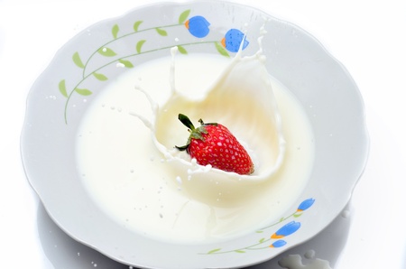 Strawberries splashing in to milkの写真素材