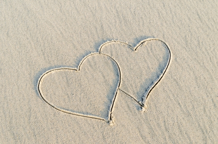 Hearts drawn on the sand of a beachの写真素材