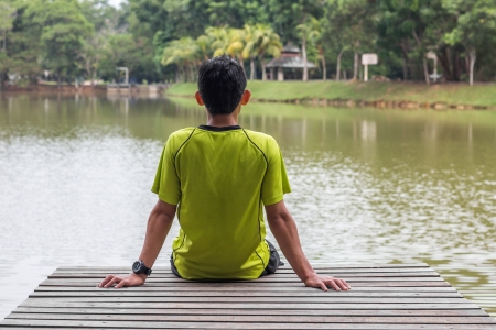 man sitting on a wooden pierの写真素材