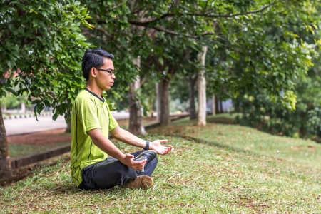 Young man meditating outdoorsの写真素材