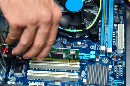 Close-up of technician's hand assembling personal computer