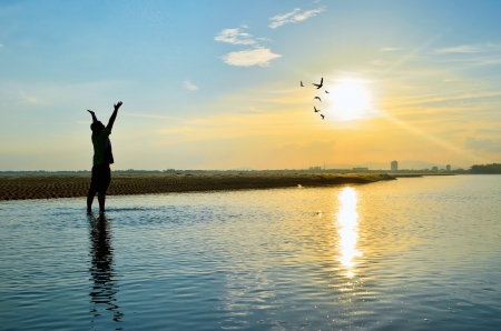 Silhouette of Man Raising His Hands or Open arms when sunsetの写真素材