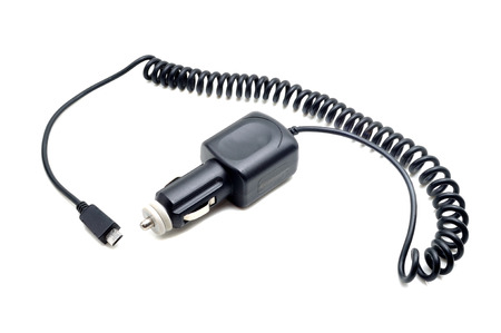 Car battery charger for mobile phones, laptops, etc. Charges your cell phone via the mini-USB connector. Fits into your car cigarette lighter socket. Isolated on white backgroundの写真素材