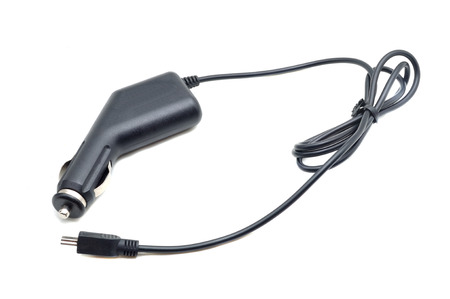 Car battery charger for mobile phones, laptops, etc. Charges your cell phone via the mini-USB connector. Fits into your car cigarette lighter socket. Isolated on white backgroundの写真素材